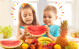 Niños sosteniendo sandía y frutas.